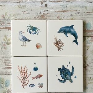 SET OF FOUR CERAMIC COASTERS WITH SEA LIFE ILLUSTRATIONS HEAVY CORK BOTTOMS. NEW